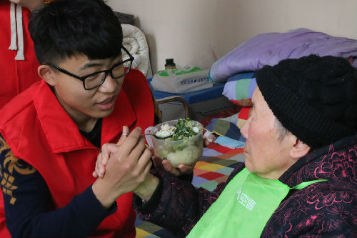 志愿者给老人喂饭.JPG